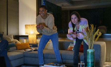 Friends playing a video game in the living room.
