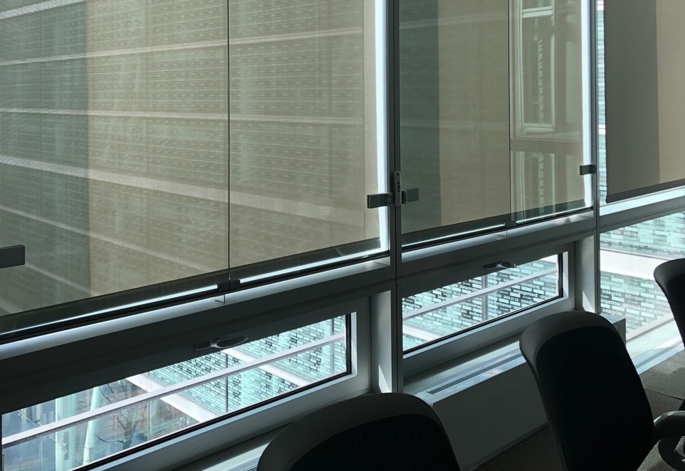 Interior shot showing Somfy powered shades lowering over windows.