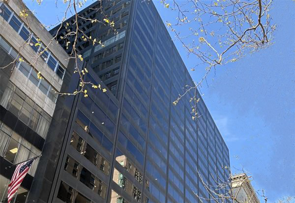 Looking up to the blue sky with the SEPTA Headquarters in the foreground showcasing all the windows on the front facade of the building.