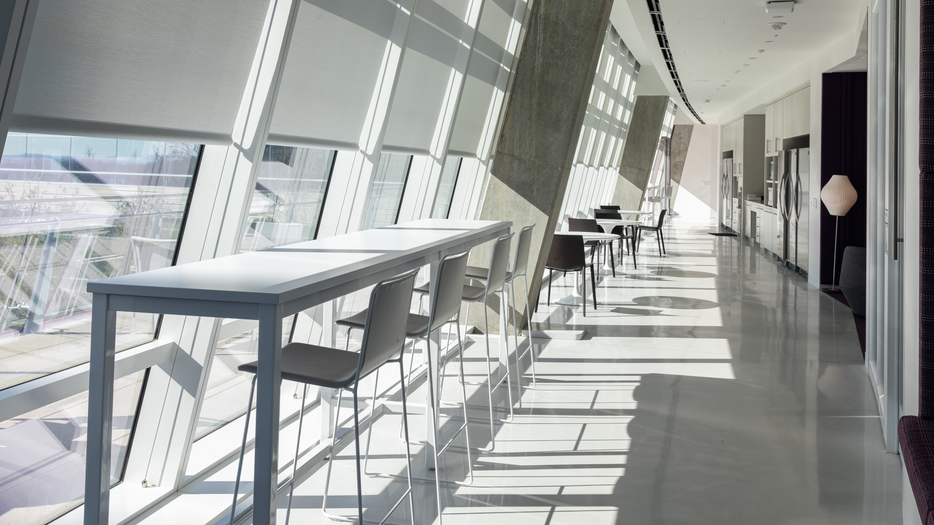American Airlines office kitchenette with seating facing toward windows with motorized shades rolled up.