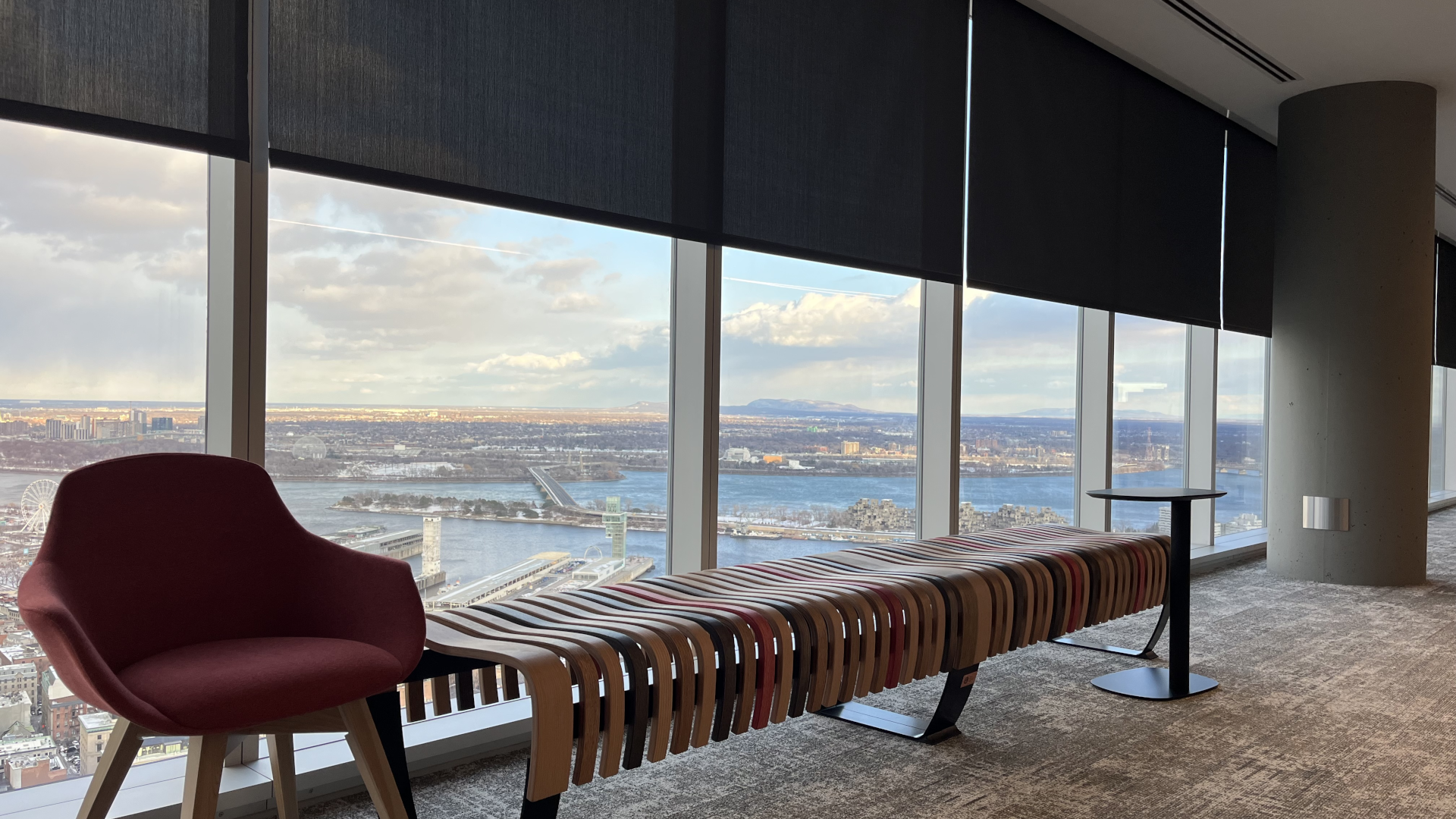Sitting area of the National Bank of Canada's headquarters overlooking the Montreal skyline with rolling shades partially lowered.